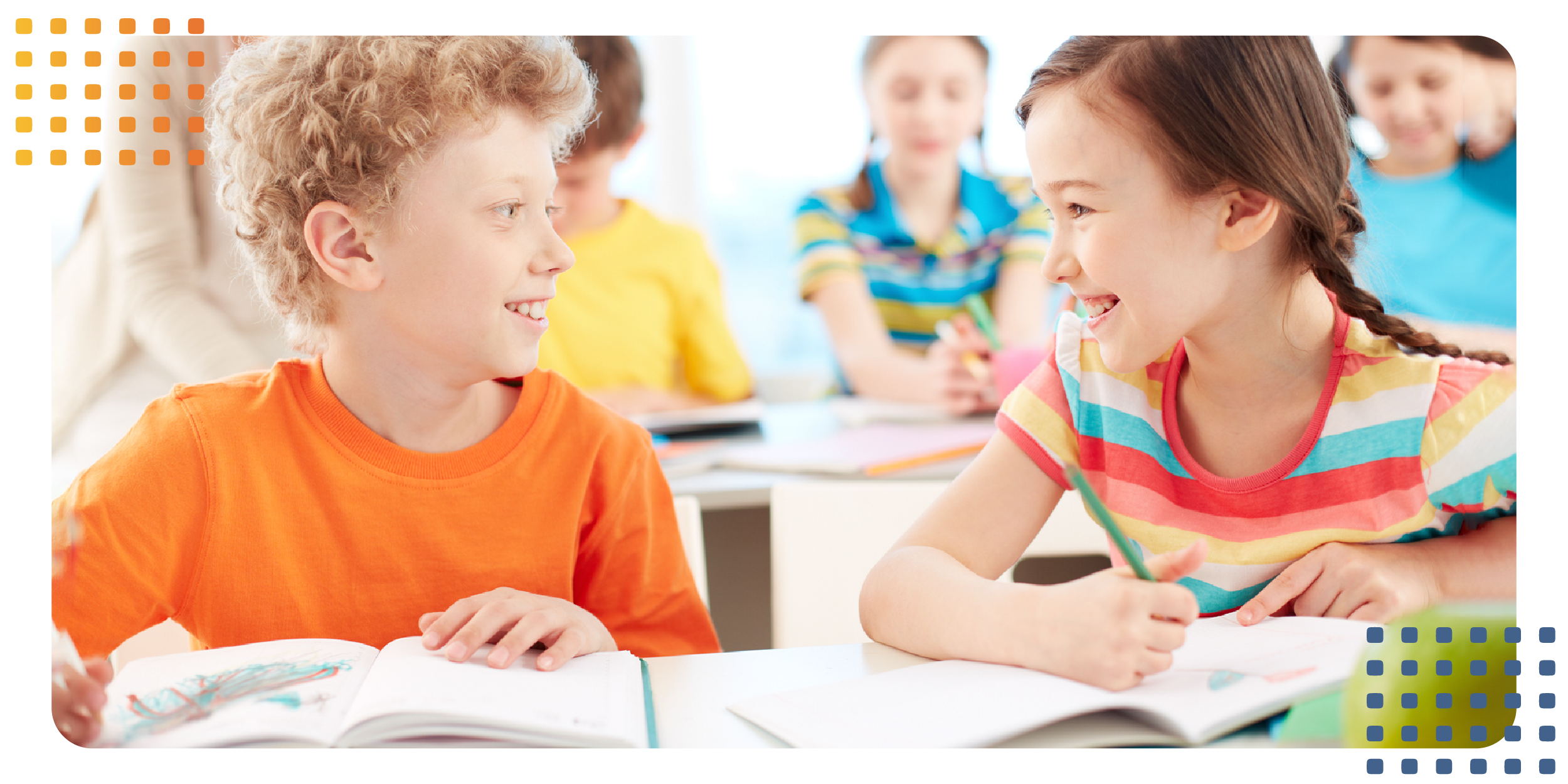 a young girl and boy sitting together in a classroom