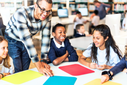 teacher laughs with group of students